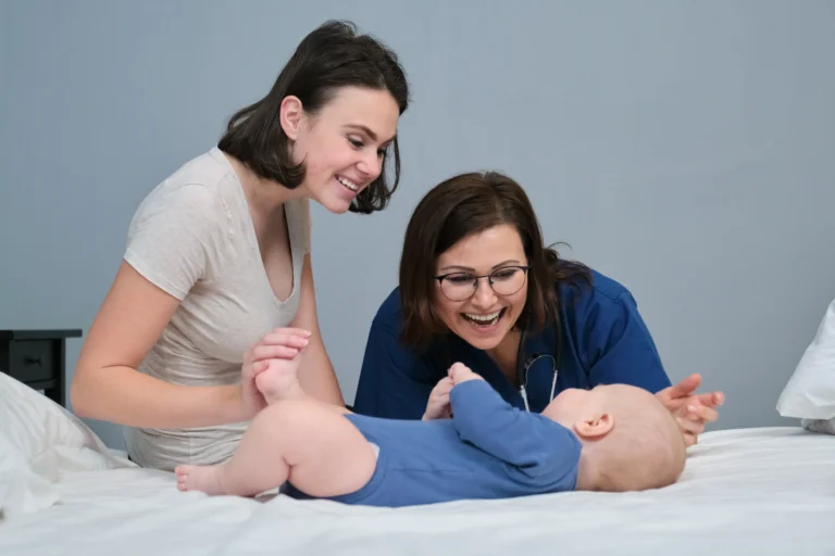 Pediatrician woman doctor in blue uniform with stethoscope talking to young mother of little boy