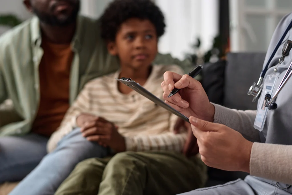 Close up of unrecognizable nurse holding clipboard while consulting African American family copy space